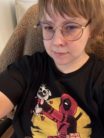 Selfie Veerasta. Mustan t-paidan printtiluvassa on Deadpool pitämässä käsissään maailman ruminta koiraa ylhäällä aivan kuten Leijonan Kuningas -animaatioelokuvassa, jossa Simba nostetaan ylös kallion reunalla.