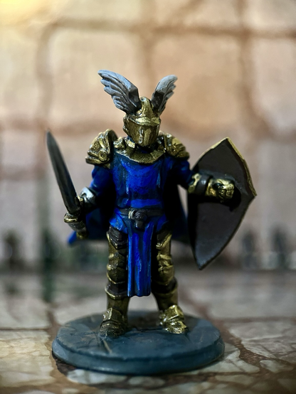 A blue fantasy knight in gold armour with blue trim.