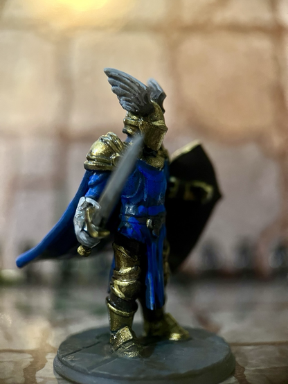 A blue fantasy knight in gold armour with blue trim.
