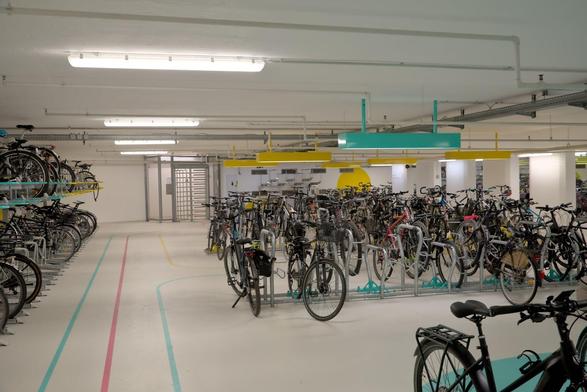 Fahrradstation am Karlsruher Hauptbahnhof mit vielen abgestellten Rädern und bunten Bodenmarkierungen.