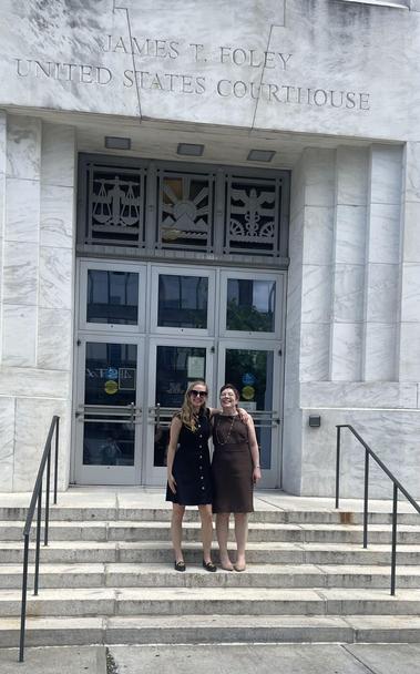 Sarah Ruhlen and Megan Thomas stand on the steps of the James t. Foley United States Courthouse after winning a big victory for our client