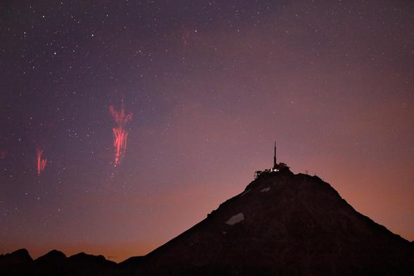 La nuit du 24 au 25 a offert une chance unique, avec une fréquence de farfadets assez incroyable... et une possibilité d'alignement avec le Pic du Midi. Une configuration calculée par Jean-François Graffand, et de laquelle j'ai eu l'aubaine de profiter par concours de circonstances... Merci !

Nuit du 24 au 25 juin 2025 – Hautes-Pyrénées

___

Version carnet de bord : 

Féerie pour les Ténèbres

Il fait lourd au-dessus de la station. Les bâtiments plantent des formes cubiques dans la pentes, et les pistes et paravalanches rayent les faces de leurs sillons rectilignes. Les lignes de crêtes sont esthétiques, se succédant au-dessus d'éboulis rosés, mais le côté sauvage semble éclipsé par cette densité d'installations humaines. Le soleil cuit les herbes bien tondues par un groupe de brebis qui carillonne en bêlant. 

Sur les rochers gris, des arbustes s'accrochent de leurs racines tordues et le lichen pose des touches d'orange et de jaune pâle. Un rouge-queue proteste vivement contre le vent qui l'ébouriffe, et un grand cercle de vautours plane silencieusement dans le ciel encore bleu qui précède un mur de cumulonimbus, véritables châteaux boursouflés et intangibles.

(suite sur l'image suivante...)