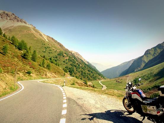 a mountain road with a bike parked on the right side