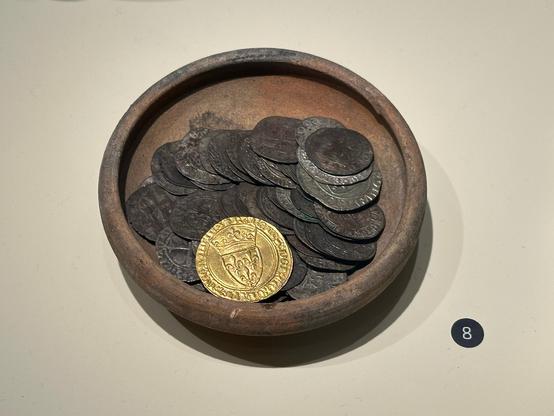 A bunch of grimy, tarnished discs of copper, bronze etc and one absolutely gleaming gold one