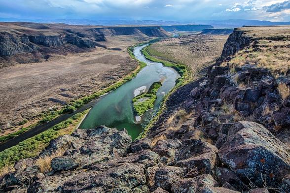A river flowing through a basalt canyon in an arid region.