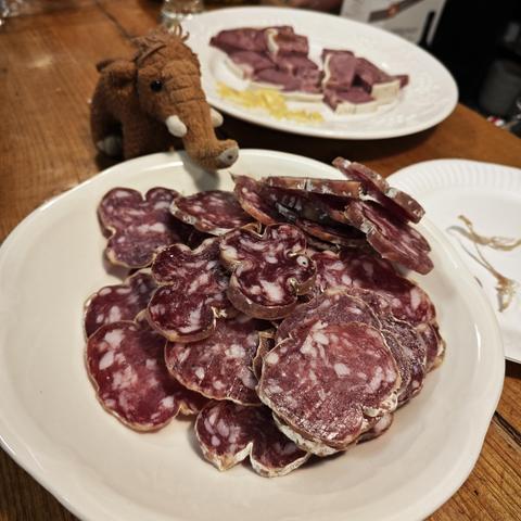 Manni vor einem Teller mit französischer Salami