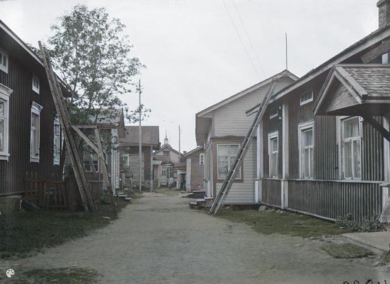 puurakennuksia Iissä. (1924, Museovirasto, Historian kuvakokoelma)

Alkuperäisen valokuvan on ottanut Signe Brander. Tämä kuva on keinotekoisesti väritetty DeOldify-algoritmilla.