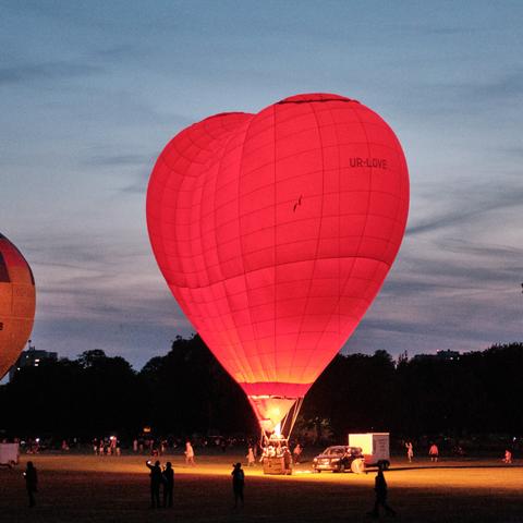 Foto eines roten Ballons in Form eines Herz vor nächstlichem Himmel; photography of a red ballon in shape of a heart and nightly background