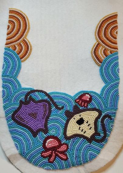 an in progress beading project made by kiamichi of a trim meant for moccasins. it depicts an ocean environment with jellyfish and stingrays among the blue ways