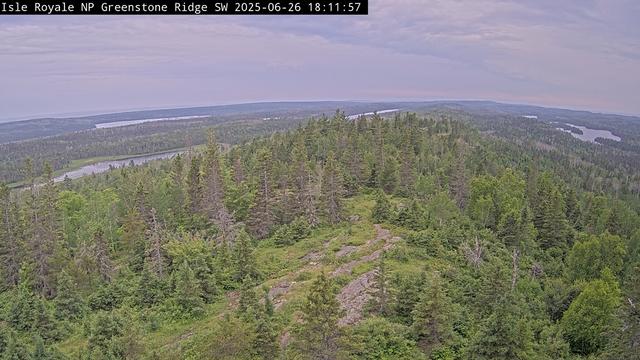 From one of the highest Isle Royale peaks at 1,133 feet above sea level (roughly 530 feet above Lake Superior), the Greenstone Ridge Southwest Webcam at the peak of Mount Ojibway gazes across the spine of the Greenstone Ridge from the Ojibway Tower. It captures a southwest vantage point, a swath from Moskey Basin on the left to Sargent Lake on the right. The webcam is solar powered and communicates multiple times per day, year-round, when power and communications infrastructure allows.