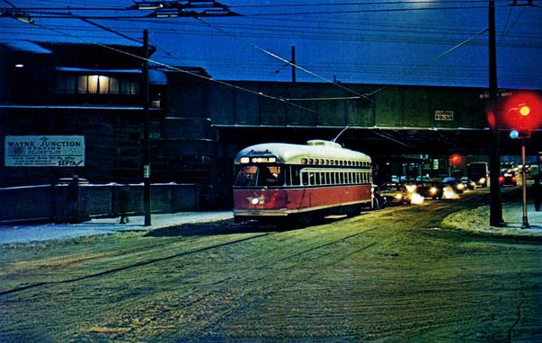 Trolley makes its way under a bridge at night.