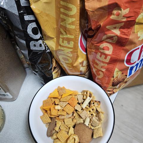 a bowl of three types of chex mix, cheddar, bold, and honeynut. a similar fashion to that of chicago popcorn mix tins like you can get at christmas times in the U.S.
