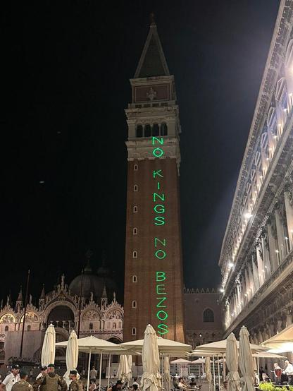 La scritta “NO KINGS NO BEZOS” proiettata con laser verde sul campanile di piazza San Marco, a Venezia.