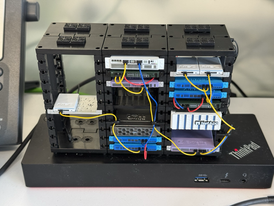 Three tiny server racks made of plastic filled with various tiny servers from real vendors like Dell or NetApp. Japanese capsule toy.