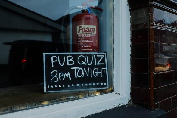 A sign advertising a pub quiz in a pub window.