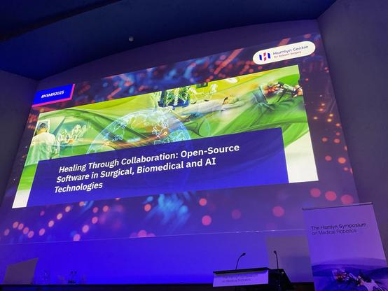 Stage with Welcoming slide for the Healing through Collaboration workshop on open source use in Surgical, Biomedical and AI at Hamlyn Symposium on Medical Robotics