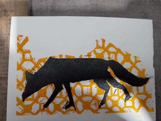 Un petit renard noir sur un fond à motif jaune
