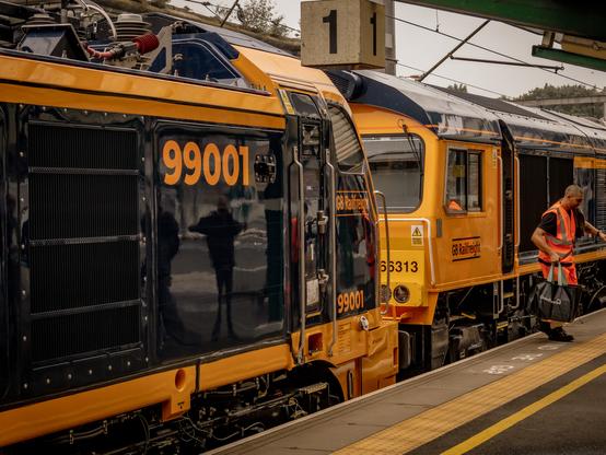 the front of Class 99, 99001, coupled to Class 66, 66313, in Carlisle station platform 1