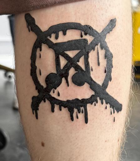 tattoo showing a crossed out musical note inside a circle