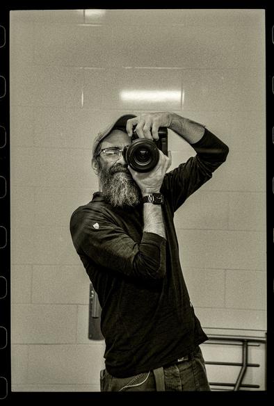 Black and white selfie in a bathroom mirror.
