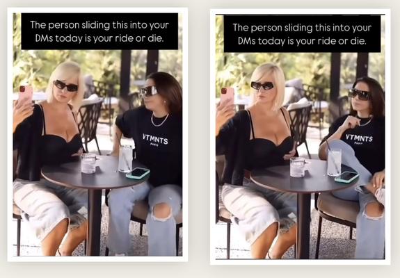 Two women sitting at a table at an outdoor cafe. One has very ample cleavage and is trying to take a selfie