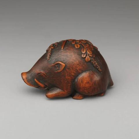 There's nothing that I can add to the description in the text. A lovely little brown Netsuke depicting a boar. The boar has foliage on its back and the variation of colours and surfaces suggest surface patination commensurate with its age and use.