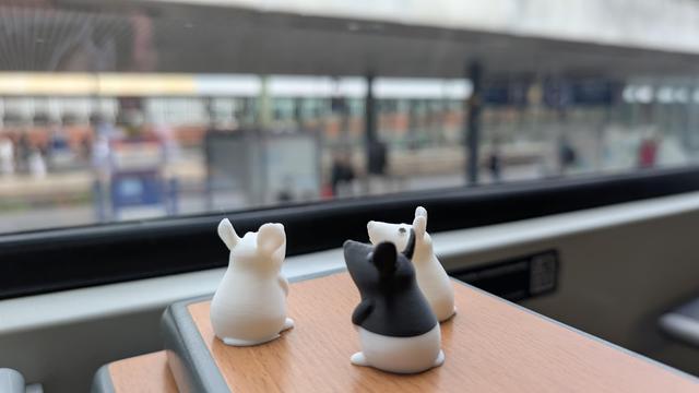 Drei Mäuse auf dem Tisch die im Bahnhof Hannover aus dem Fenster schauen.
