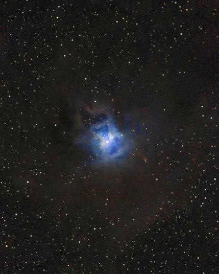 Photo of NGC 7023, the Iris Nebula, a bright reflection nebula in the constellation Cepheus, taken at Bubulcus & Bolotas. A brilliant blue glow surrounds a central star, with dark dust lanes and a star field in the background.