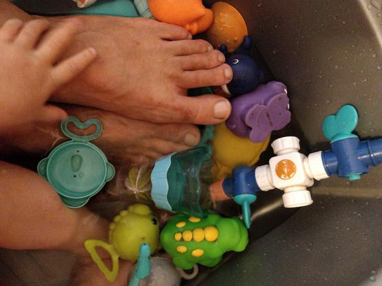 Pieds au milieu de jouets de bain
