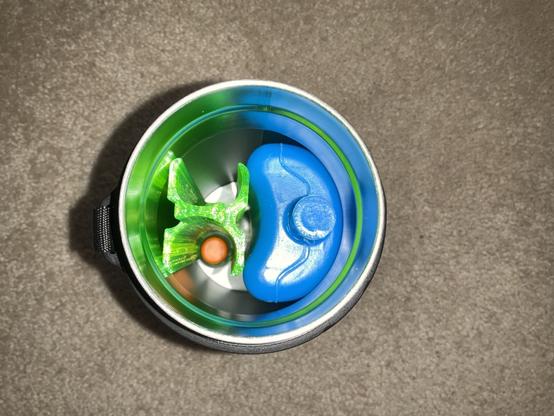 top down view of a metal thermos with a blue icepack and a green printed sleeve