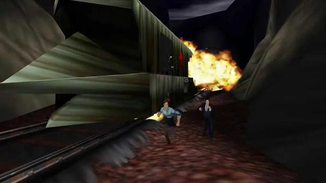 A screen shot from GoldenEye 007. Natalya and James Bond are fleeing a train that has a big firey explosion. Everything is very low-poly.