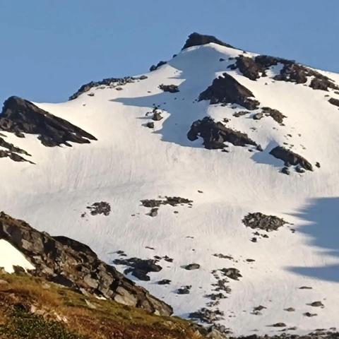 Slettinden! A snow covered peak. We climbed the ridge to the left to a cliff band just out of frame that we could not downclimb with packs and skis on, so we had to retreat, doenclimb off the ridge out of frame and ski up the snow just below the rocks in a rising traverse.