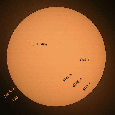 Along the Sun's visible surface are a few sunspots numbered 4117 - 4122.