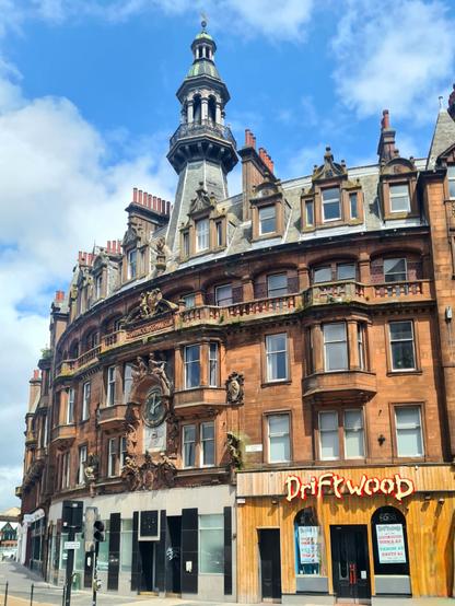 An ornate red sandstone Glasgow tenement building.