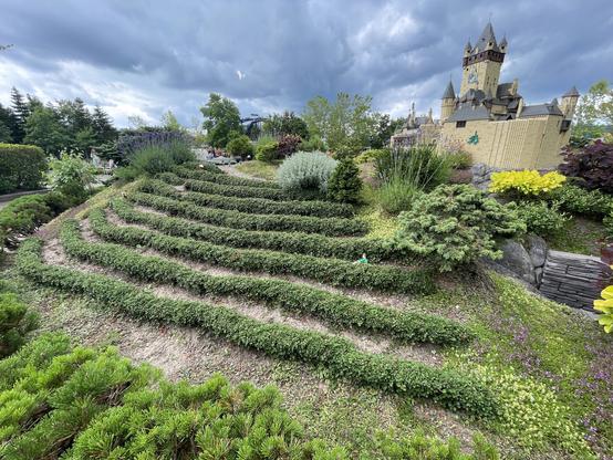 Un castillo hecho de fichas de lego. Un jardín hecho con bonsais