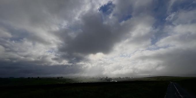 A view back over the valley, the village is under dark brooding clouds