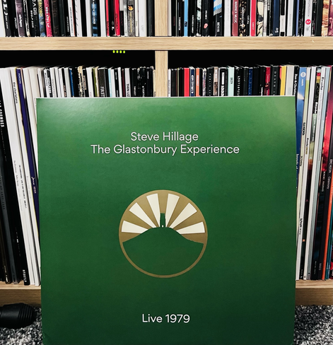 A stylised circular motif of Glastonbury Tor with sun rays beaming from behind is the centrepiece of this album surrounded in a solid green background with the artist’s name and album title in a white text centred above.