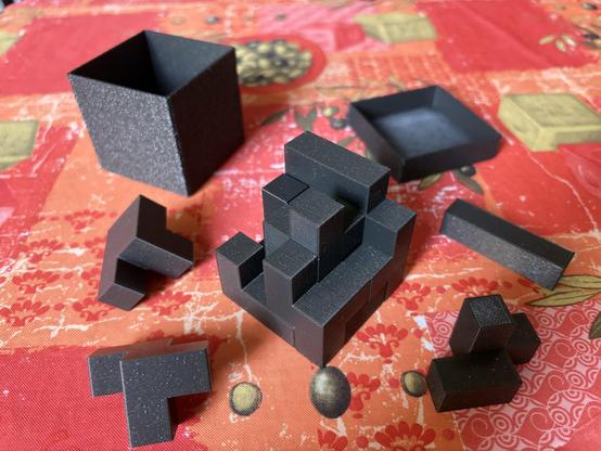 Box for a 4x4x4 cube which should be composed of given pieces of mostly irregular forms, made of 1x1x1 cubelets.