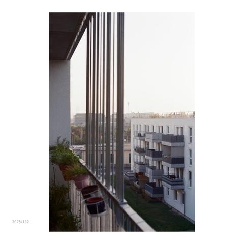 Blick auf Neuleopoldau vom Balkon aus. Es ist später Nachmittag mit untergehender Sonne und ein friedlich warmes Licht taucht das Stadtviertel ein.