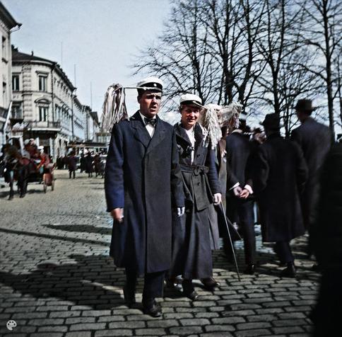 Vapunviettäjiä vappuhuiskat lakeissaan Pohjois-Esplanaadikadulla (Pohjoisesplanadilla) 1. (1919, Helsingin kaupunginmuseo)

Alkuperäisen valokuvan on ottanut Ivan Timiriasew. Tämä kuva on keinotekoisesti väritetty DeOldify-algoritmilla.