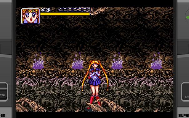 A screenshot from Bishoujo Senshi Sailor Moon for SNES.
Sailor Moon is standing in a grey and brown corridor, lit by ominous purple flames. In the foreground are odd rock formations that look like hands.

The walls and floors have a weird mechanical vibe to them.