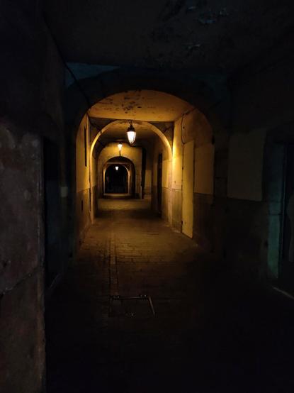 Interior de un pasadizo iluminado desde arriba. El pasadizo está compuesto de una serie de arcos que hacen un bonito juego de luces y sombras.