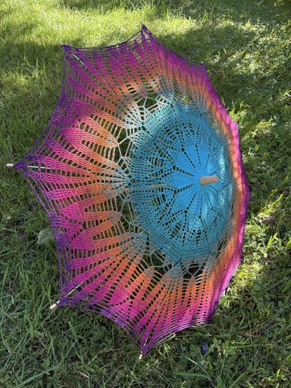 Colourful parasol on green grass.