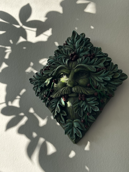 A wall mounted green man that hangs in my hallway gets a glimmer of setting sun in his right eye this time of year.