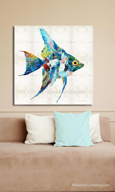 Colorful angelfish art over a sofa and pillows.  Art by Sharon Cummings.