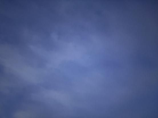 A vast blue sky with scattered clouds is seen.