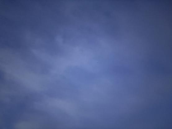 A vast blue sky with scattered clouds is seen.