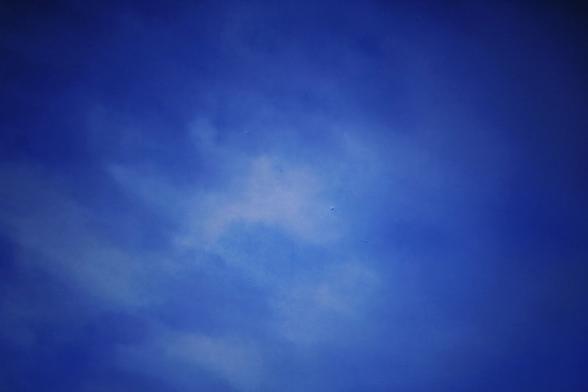 A vast expanse of deep blue sky with scattered clouds.