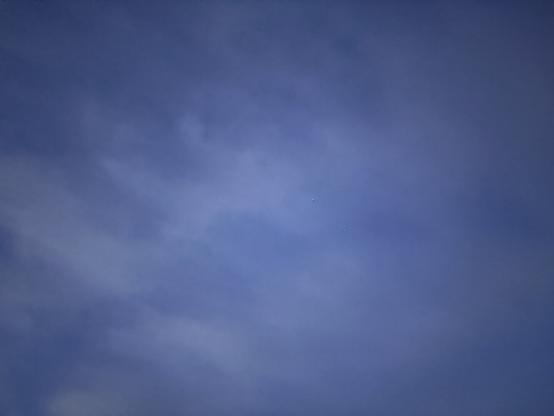 A vast blue sky with scattered clouds is seen.