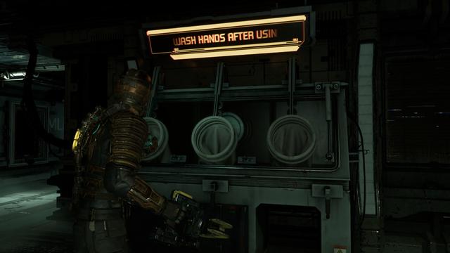 A medical clean room station with those things doctors put their hands into and manipulate gloves inside the sterile area. 
An illuminated sign at the top reads: WASH HANDS AFTER USING
